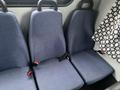 Three blue upholstered seats with seat belts in a Chevrolet Express interior