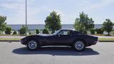 A 1971 Chevrolet Corvette Stingray in a deep shade of black with a sleek design and chrome accents showcasing its iconic sporty profile