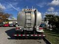 A 2013 Kenworth T370 truck with a large metal tank in the back and a ladder on the side