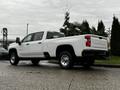 A white 2021 Chevrolet Silverado 3500HD pickup truck is parked with its side view visible showcasing its large wheels and truck bed