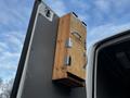 A wooden box with metal handles mounted on the side of a 2017 Mercedes-Benz Sprinter van