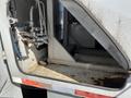 Close-up of the interior compartment of a 2010 Freightliner MT45 Garbage Truck showing pipes and controls inside a metal structure