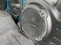 A black Alpine subwoofer mounted in the interior of a 2020 Jeep Wrangler