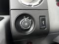 Close-up of a control panel featuring a knob for light settings and a switch for fog lights in a vehicle interior