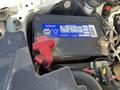 A 2013 Ford Expedition vehicle battery with a blue label and a red positive terminal visible