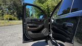 A 2018 Chevrolet Tahoe with its driver's side door open, showcasing the interior door panel and controls