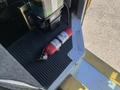 A fire extinguisher secured on the floor inside a 2012 Ford Econoline van