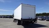 A white 2009 Hino 268 box truck is parked with its rear facing the viewer showcasing its plain back and trailer door