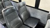 The interior of a 2014 Freightliner Thomas Bus Diesel featuring gray vinyl seats with a ribbed design arranged in rows