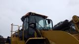 A 2019 Caterpillar 972M XE wheel loader with a large front bucket and a driver's cabin featuring multiple lights and a sturdy structure