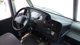 The interior dashboard of a 2011 Ford Econoline featuring the steering wheel various controls and instruments including lights and gearshift