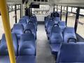 Interior of a 2018 Chevrolet Express bus featuring multiple blue upholstered seats arranged in rows with a central aisle