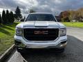 A white 2017 GMC Sierra 1500 pickup truck facing forward with a prominent black grille and red GMC logo