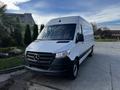 A 2022 Mercedes-Benz Sprinter van in white with a black front grille and headlights parked at an angle