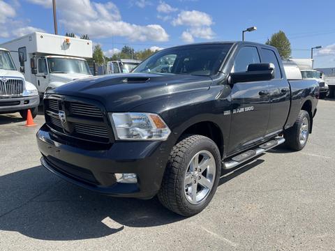 A 2011 RAM 1500 pickup truck in black with chrome accents a six-foot bed and chrome side steps featuring a bold grille and a sleek design