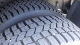 Close-up of a tire from a 2011 Ford Econoline showcasing rugged tread patterns designed for traction and durability