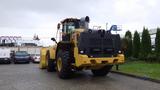 A 2019 Caterpillar 972M XE wheel loader with large tires and a front bucket attachment positioned at the rear view