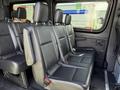 Interior of a 2019 Mercedes-Benz Sprinter showcasing a row of black leather seats with seatbelts