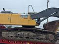 A 2014 John Deere 350G excavator in yellow and black with a large bucket attached on a flatbed truck