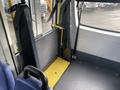 A yellow wheelchair ramp is positioned inside a vehicle next to a gray panel with a textured surface