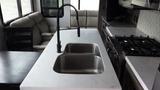 A modern kitchen countertop with a dual stainless steel sink and a stylish black faucet inside a 2021 Forest River Cedar Creek RV