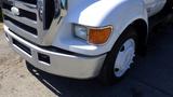 A white 2006 Ford F-650 truck with a prominent front grille and round headlights parked on a concrete surface