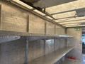 Interior of a 2007 Freightliner MT55 truck with metal shelves along the sides showcasing a spacious cargo area