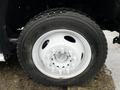 Close-up of a 2014 Ford F-550 wheel displaying a silver rim and tire with visible tread patterns