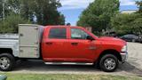 A red 2013 RAM 2500 pickup truck with a silver utility bed visible on the left side