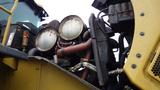 Close-up of the engine compartment of a 2019 Caterpillar 972M XE highlighting the large round headlights and various mechanical components