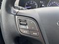 Close-up of the steering wheel controls of a 2017 Hyundai Santa Fe showing volume mute and mode buttons