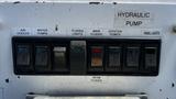 Controls for a hydraulic pump featuring multiple switches labeled for air cooler water pumps floods lights main floods joystick power and panel lights