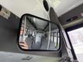 Interior view of a 2010 Ford Econoline van showcasing gray seats and a reflection in the side mirror