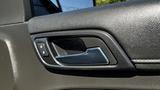 Close-up of the interior door handle of a 2018 Chevrolet Tahoe featuring a sleek design with a button for locking and unlocking doors