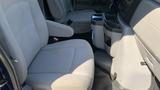 Interior view of a 2013 Ford Econoline with gray fabric seats and a central console featuring cup holders