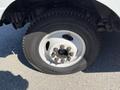 Close-up of a silver wheel with six lug nuts on a tire of a 2011 Ford Econoline