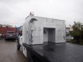 A white 2009 Ford F-450 SD with a flatbed and a large metallic utility box mounted on the back featuring multiple access points and a light fixture