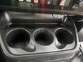 A cup holder console with three circular indentations designed to hold beverages in a 2017 Chevrolet Express