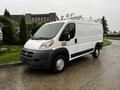 A white 2018 RAM Promaster van with roof racks parked on a paved surface