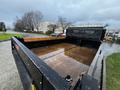 A 2021 Ford F-550 dump truck with an open bed showing puddles of water inside