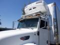 A 2008 Peterbilt 335 truck with a prominent front grille and top-mounted refrigeration unit