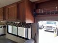 Interior view of a 2012 Ford Econoline with wooden cabinets and a decorative curtain above the windows