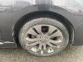 A 2014 Subaru Impreza with a dark gray alloy wheel and a tire showing visible wear and rain droplets on the surface