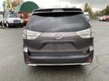 A gray 2013 Toyota Sienna seen from the rear with the model name "Sienna" displayed on the back hatch and LED taillights