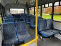 A 2017 Chevrolet Express interior featuring rows of blue and gray patterned seats with yellow handrails