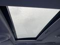 A panoramic sunroof of a 2007 Mercedes-Benz E-Class with water droplets on the glass