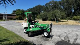 A 2017 Laymor SweepMaster 300 street sweeper with a green and white color scheme featuring a large front broom and operator seat