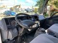 Interior view of a 2015 Isuzu NPR showcasing the driver's seat steering wheel dashboard and control panel