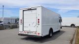 A white 2011 Ford Econoline truck with a large cargo area and rear roll-up door visible from the back