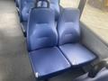 Two blue fabric bus seats with some wear and tear